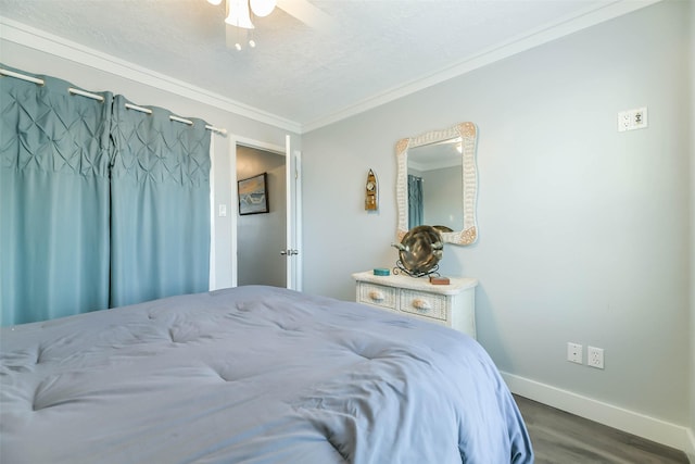 bedroom featuring a textured ceiling, a ceiling fan, ornamental molding, wood finished floors, and baseboards