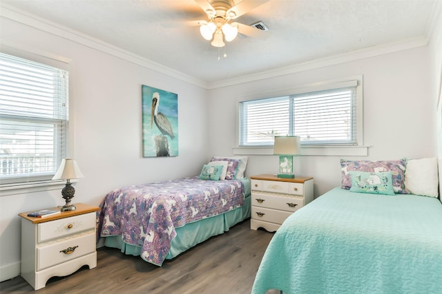 bedroom with crown molding, visible vents, ceiling fan, and wood finished floors