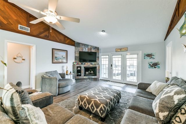 living room with wood finished floors, visible vents, a ceiling fan, and vaulted ceiling