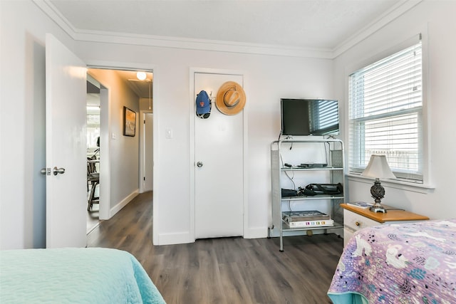 bedroom featuring baseboards, ornamental molding, and wood finished floors