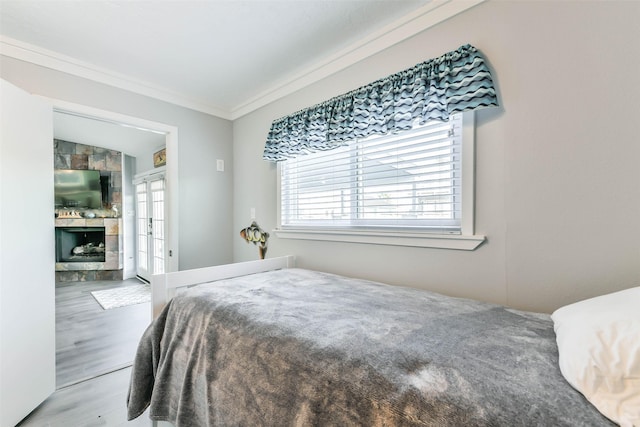 bedroom featuring french doors, crown molding, and wood finished floors