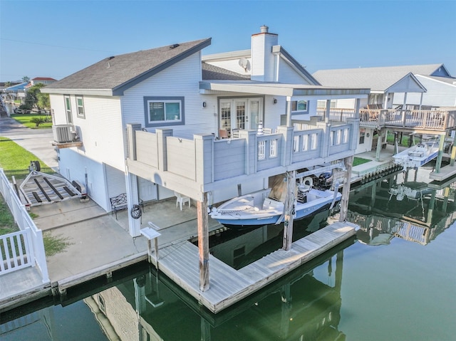 view of dock featuring a water view, central air condition unit, and boat lift