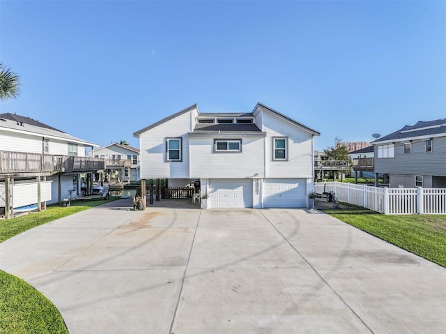 exterior space featuring fence, a residential view, a garage, and concrete driveway