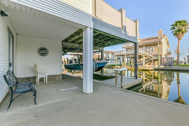view of patio / terrace with a water view, a boat dock, and boat lift