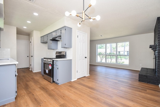19918 Burle Oak Dr, Humble, TX 77346 - kitchen featuring electric range, under cabinet range hood, gray cabinetry, and light wood-style floors