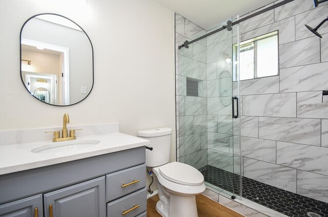 19918 Burle Oak Dr, Humble, TX 77346 - full bathroom featuring toilet, a shower stall, vanity, and wood finished floors