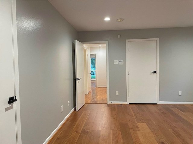 interior space featuring baseboards, wood finished floors, and recessed lighting