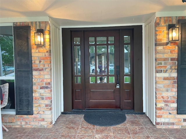 entrance to property featuring brick siding