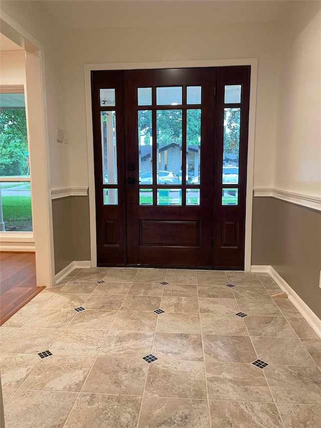 foyer entrance featuring baseboards and a healthy amount of sunlight