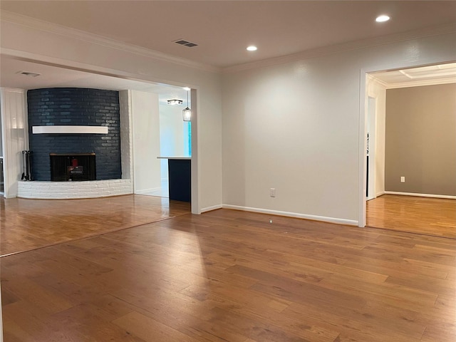 unfurnished living room featuring wood finished floors, visible vents, and crown molding