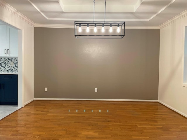 unfurnished dining area with baseboards, wood finished floors, a tray ceiling, and ornamental molding