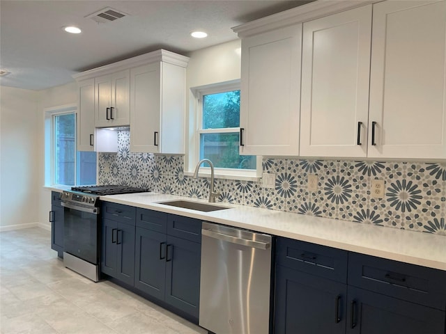 kitchen with stainless steel appliances, a sink, visible vents, white cabinetry, and light countertops