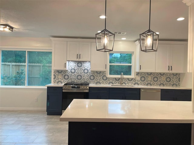 5475 Jackwood St, Houston, TX 77096 - kitchen with appliances with stainless steel finishes, a sink, light countertops, backsplash, and white cabinetry