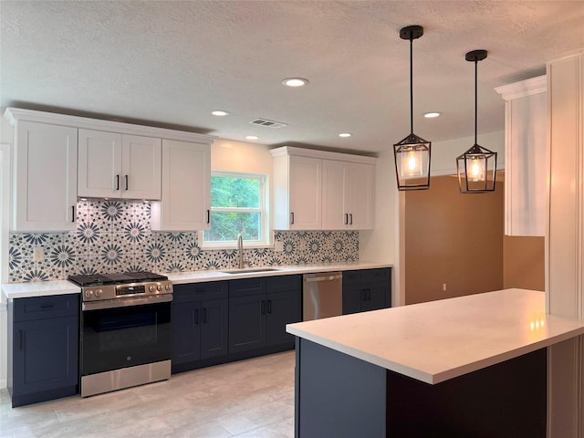 kitchen with a sink, stainless steel appliances, light countertops, white cabinets, and visible vents