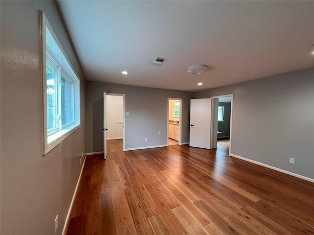 unfurnished bedroom featuring recessed lighting, wood finished floors, visible vents, and baseboards