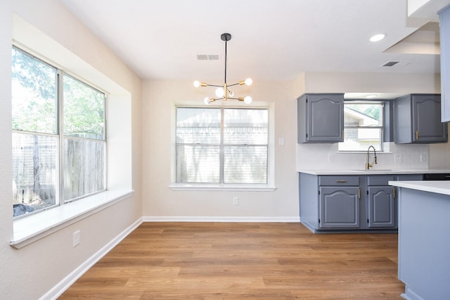 19919 Burle Oak Dr, Humble, TX 77346 - kitchen with visible vents, a chandelier, a sink, light countertops, and gray cabinetry