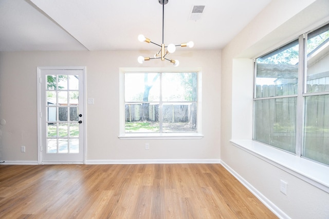 19919 Burle Oak Dr, Humble, TX 77346 - unfurnished dining area with visible vents, light wood-style flooring, a chandelier, and a healthy amount of sunlight