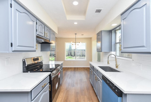 19919 Burle Oak Dr, Humble, TX 77346 - kitchen with electric range, gray cabinetry, under cabinet range hood, dishwashing machine, and a sink