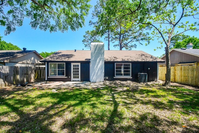 19919 Burle Oak Dr, Humble, TX 77346 - rear view of property with a patio, a chimney, a fenced backyard, central AC, and a yard