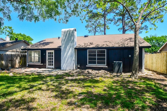 19919 Burle Oak Dr, Humble, TX 77346 - back of property featuring a fenced backyard, cooling unit, a lawn, and a chimney