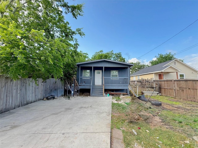 bungalow-style home with a fenced backyard and a porch