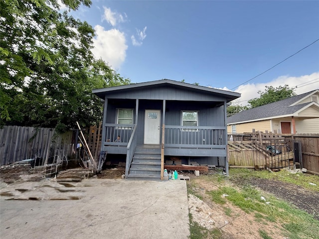 bungalow-style home with fence and a porch