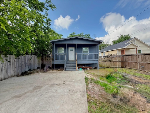 bungalow featuring a fenced backyard and a porch