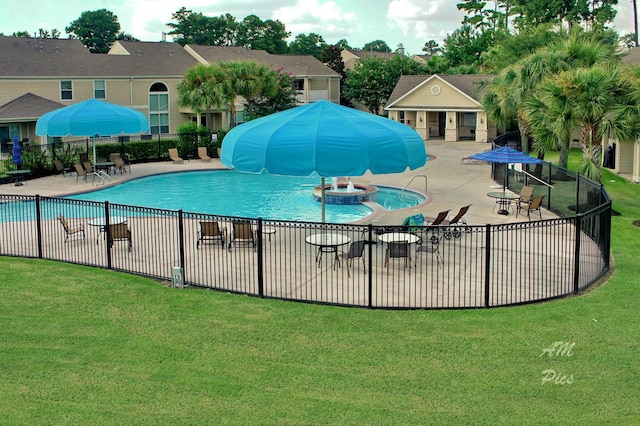 pool with a yard, a patio area, a water slide, and fence