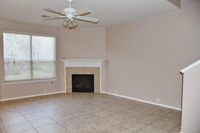 unfurnished living room featuring light tile patterned floors, baseboards, visible vents, ceiling fan, and a fireplace