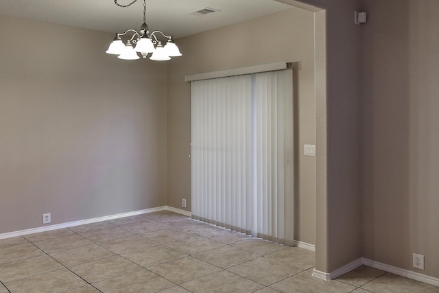 spare room featuring light tile patterned floors, visible vents, baseboards, and an inviting chandelier