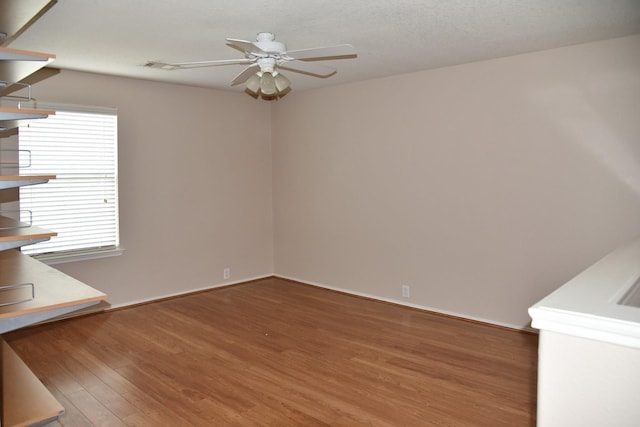 interior space featuring baseboards, a ceiling fan, and wood finished floors
