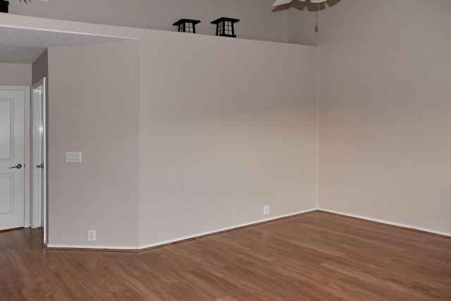 spare room featuring baseboards, a ceiling fan, and wood finished floors