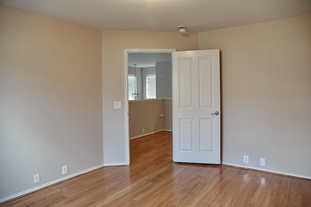 unfurnished room featuring light wood-style flooring and baseboards