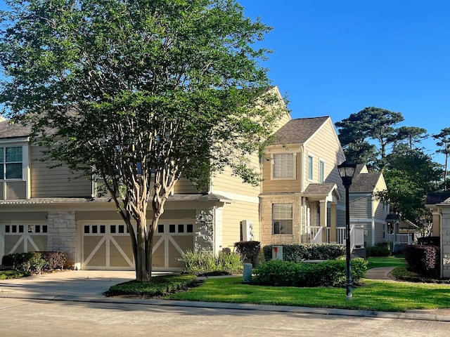 view of front of property featuring an attached garage, concrete driveway, and stone siding
