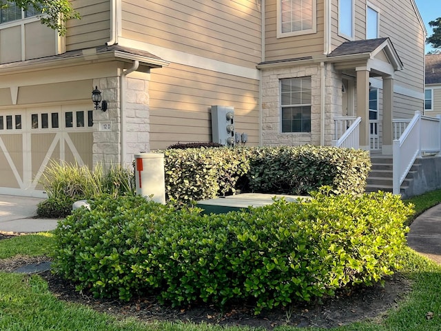 entrance to property with a garage and stone siding