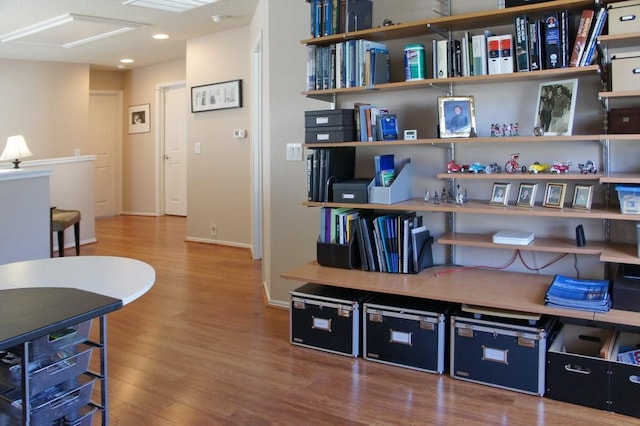 interior space featuring recessed lighting, baseboards, and wood finished floors
