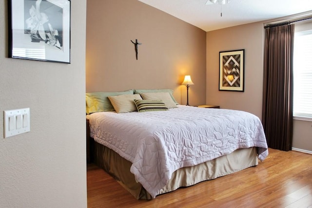 bedroom with baseboards and wood finished floors