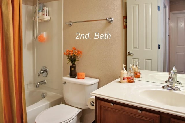 full bathroom with toilet, vanity, a textured wall, and shower / washtub combination