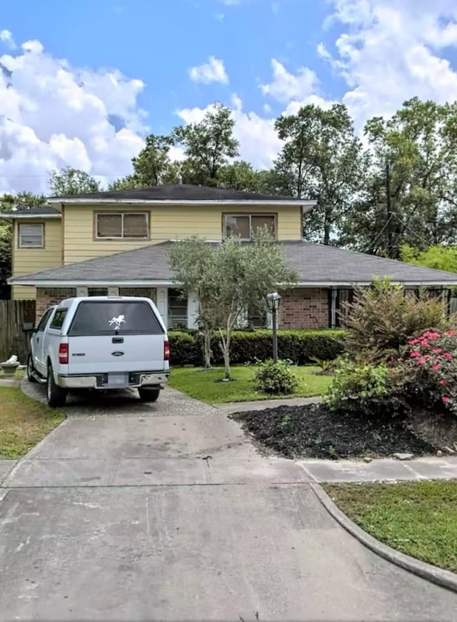 view of front facade with concrete driveway and a front yard