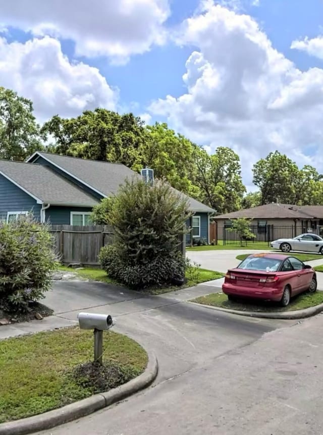 exterior space with fence and curved driveway