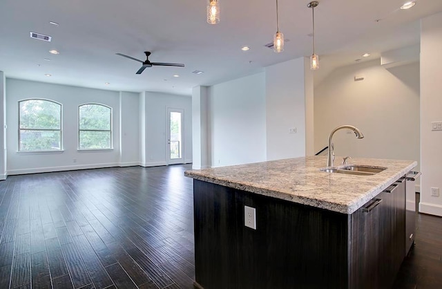 kitchen with a kitchen island with sink, open floor plan, visible vents, and a sink