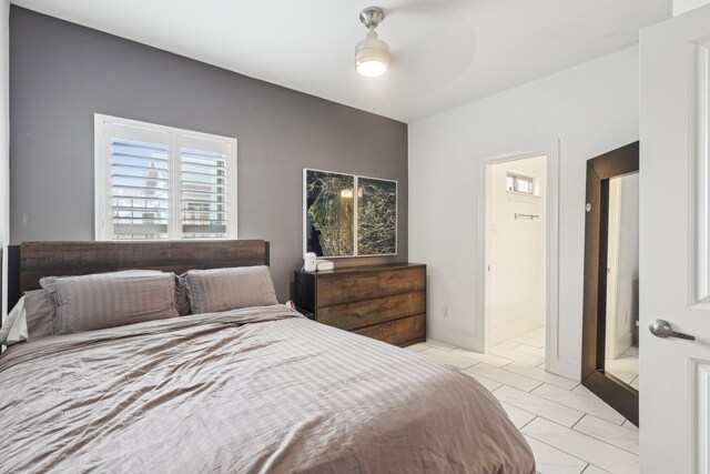 bedroom with light tile patterned floors and ensuite bath
