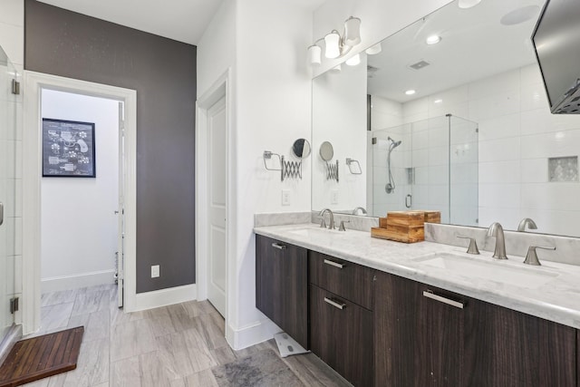 bathroom with a shower stall, double vanity, visible vents, and a sink
