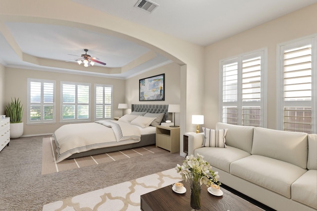 bedroom featuring arched walkways, carpet flooring, multiple windows, and visible vents