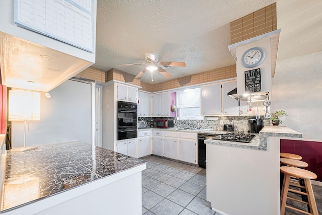 5622 Sheraton Oaks Dr, Houston, TX 77091 - kitchen with black appliances, a peninsula, ceiling fan, decorative backsplash, and light tile patterned floors