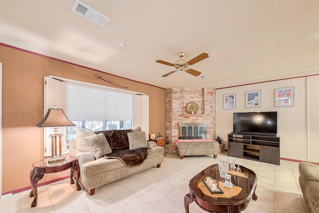 5622 Sheraton Oaks Dr, Houston, TX 77091 - living room with a ceiling fan, light tile patterned floors, a brick fireplace, baseboards, and a textured ceiling