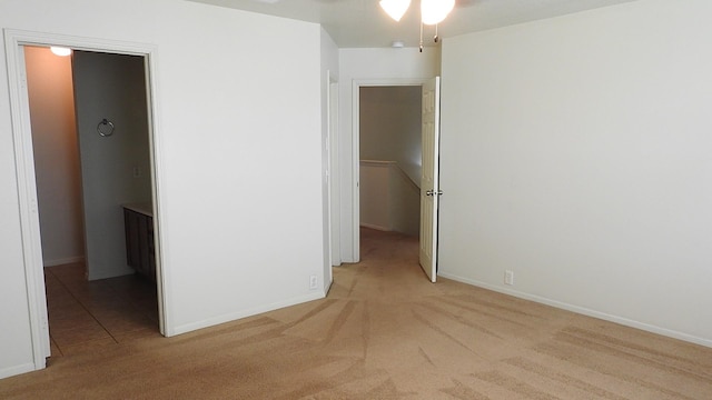 spare room with ceiling fan, carpet, and baseboards