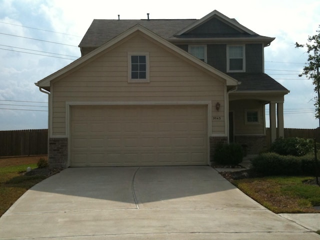 craftsman inspired home with concrete driveway and fence