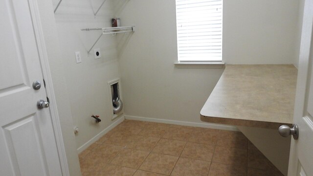 laundry room with laundry area, light tile patterned flooring, hookup for an electric dryer, gas dryer hookup, and baseboards