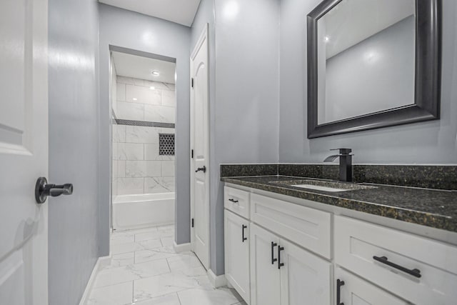 bathroom featuring marble finish floor, shower / bath combination, vanity, and baseboards